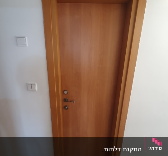דלת עץ חומה עם ידית מתכת